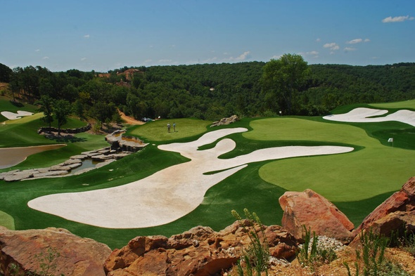 Augusta lush green synthetic grass golf course with white sand bunkers and blue sky